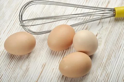 Close-up view of raw chicken eggs in egg box on wooden background. Raw chicke Stock Photos