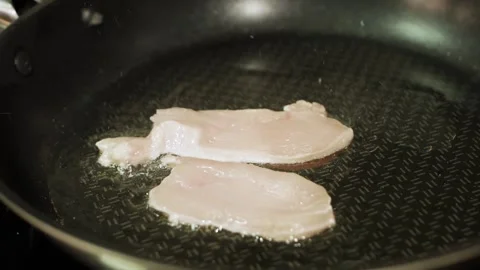 Close up view of raw chicken fillet fring on pan Stock Footage 147598820
