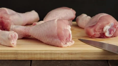 Close view of raw chicken legs on cutting board panning shot Stock Footage 104289785
