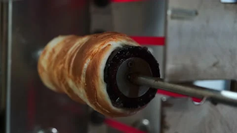 Close view of raw trdelnik, a spit cake, cooking in a store. Cooking in the oven Vidéo 146509843