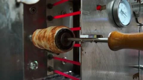 Close view of raw trdelnik, a spit cake, cooking in a store. Cooking in the oven Vidéo 146509887