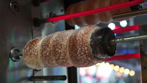 Close view of raw trdelnik, a spit cake, cooking in a store. Cooking in the oven Vidéo 146510034