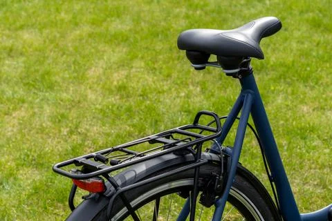 Close up view of the rear section of a modern blue bicycle featuring a comf.. 스톡 사진