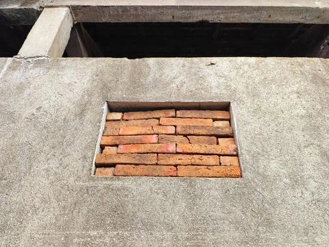 Close up view of a rectangular inset containing stacked red bricks set into a Stock Photos