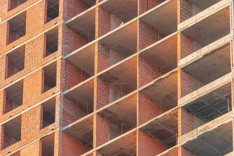 Close-up view of a red brick and steel under-construction building with recta 스톡 사진