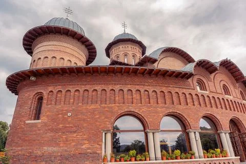 Close view of red brick cathedral facade at Curtea de Arges Monastery in Ar.. Stock Photos