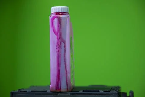 Close up view of red colored ink bottle which is used in color printer. Stock Photos