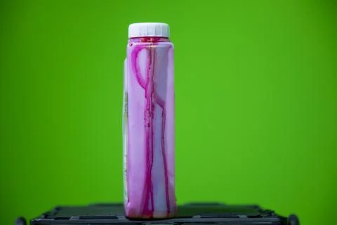 Close up view of red colored ink bottle which is used in color printer. Stock Photos