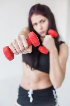 Close-up view of the red dumbbell in the focus. The background of the blurred Stock Photos