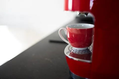 Close-up view of red espresso machine and small cup. Stock Photos