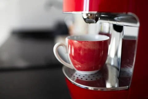 Close-up view of red espresso machine and small cup. Stock Photos