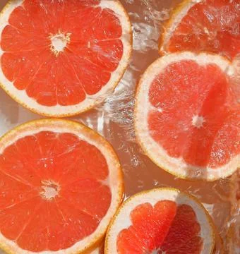 Close up view of the red grapefruit slices in lemonade background. Texture of Stock-Fotos
