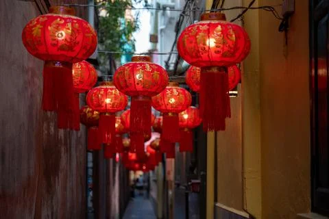 Close view of red lanterns hanging in narrow alley Bangkok Foto stock