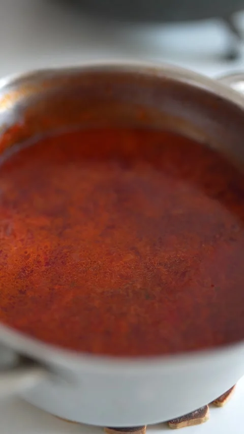 Close up view of red soup simmering in metal pot Stock Footage 330942681