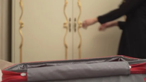 A close-up view of a red suitcase. A pretty brown-haired woman on the background Vídeo Stock 101367144