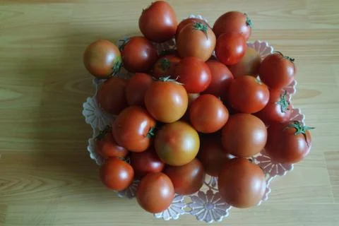 Close-up view of red tomatoes in white basket on a wooden floor in market Stock Photos