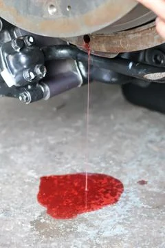Close up view of red transmission fluid leaking from a vehicle engine assem.. 库存照片