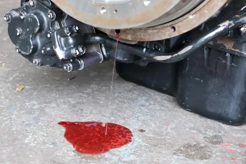 Close up view of red transmission fluid leaking from a vehicle engine assem.. 库存照片