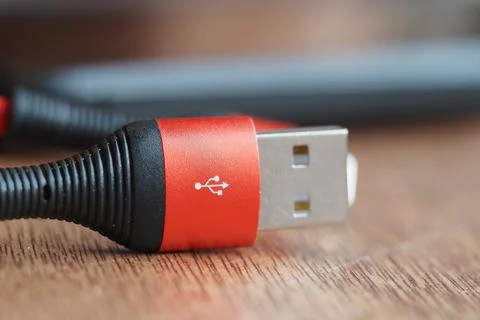 Close up view of a red USB cable on a wooden table Stock Photos