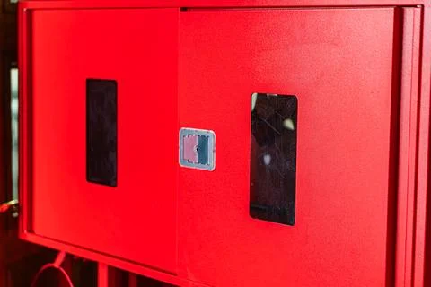 Close-up view of a reflective, angled, red fire safety shield with two dark.. Stock Photos