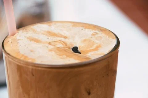 Close-up view of a refreshing iced coffee frappe drink with thick foam and .. Stock Photos