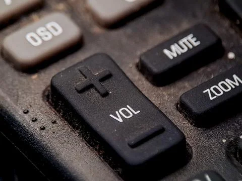 Close up view of a remote control panel showing volume mute and zoom functi.. 스톡 사진