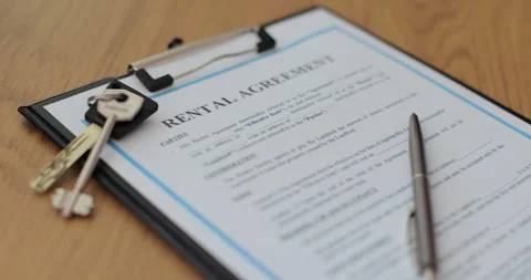 Close-up view of a rental agreement document with key, and a pen placed on top. Video stock 303134434