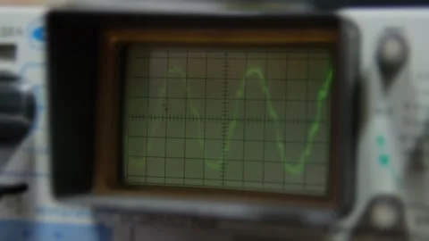 Close-up view of a retro oscilloscope screen displays a bright green waveform Stock Footage 300484776