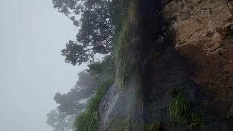 A close-up view reveals a misty mountain ridge with cascading water flowing.. Stock-Footage 346817447