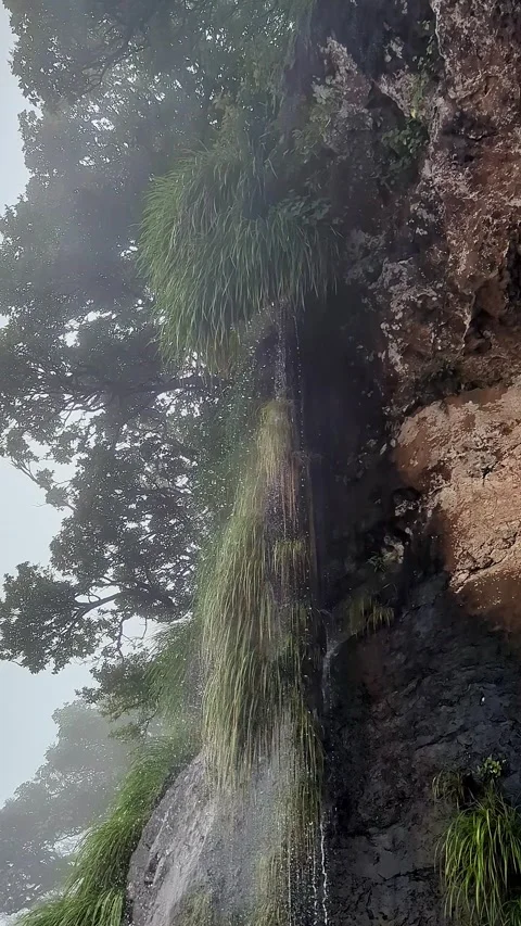A close-up view reveals a misty mountain ridge with cascading water flowing.. Stock-Footage 346817456