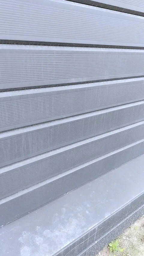 Close view of ribbed gray metal wall extending along exterior building facade Vídeos de archivo 346985592