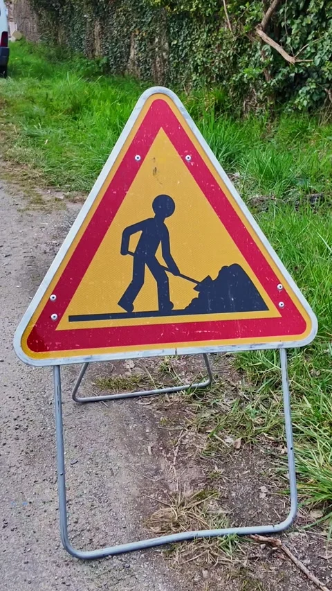 Close-up view of a roadside construction sign warning about men at work on Stock Footage 305838410