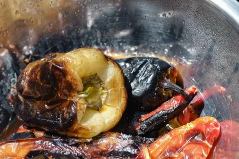 Close-up view of roasted bell peppers with charred skin inside a metallic bow Stock Photos