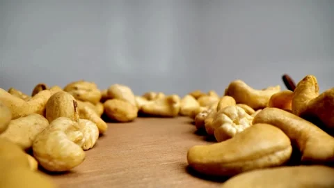 Close-up View of Roasted Cashew Nuts Scattered on Wooden Surface Stock Footage 311491899