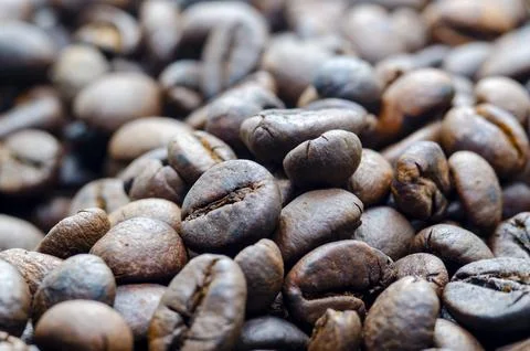 Close up view roasted coffee beans that highlights the texture and surface .. Stock Photos
