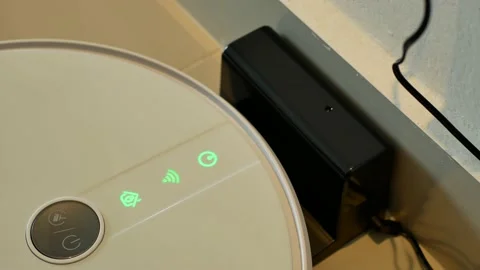 Close-up view of the robotic vacuum cleaner charging at the dock. 動画素材 130718785