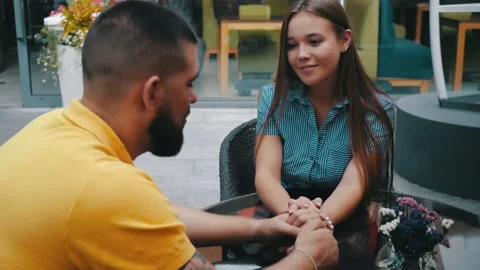 Close-up view of romantic date of young smiling cute couple in love sit in Stock Footage 134591009