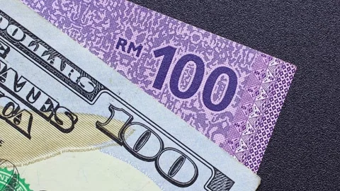 Close up view of rotating American dollar and Malaysian ringgit banknotes. Stock Footage 309826424
