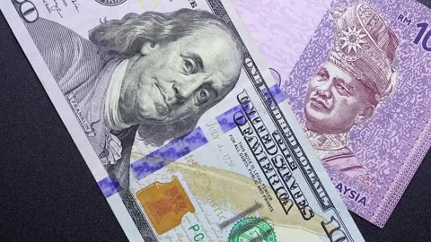 Close up view of rotating American dollar and Malaysian ringgit banknotes. Stock Footage 309827636