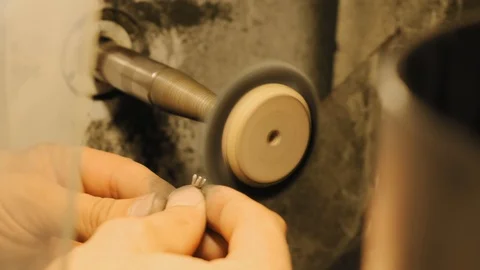 Close up view of rotating circular saw grinding the edge of the silver ring slow Stock Footage 111330990