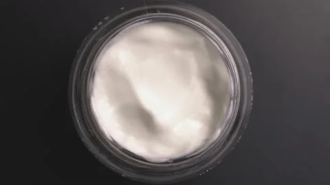 Close-up view of a rotating cosmetic cream product. Stock Footage 199742204