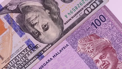 Close up view of rotating Malaysian ringgit (MYR) and 100 USD american dollars. Stock Footage 297244053
