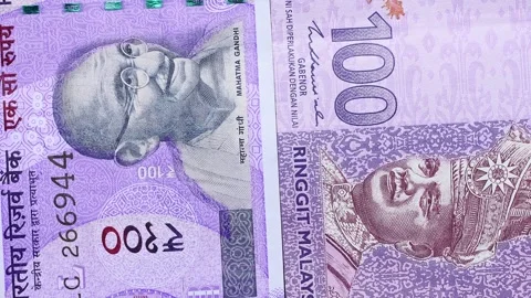 Close up view of rotating Malaysian ringgit and Indian rupee banknotes. Stock Footage 309811681