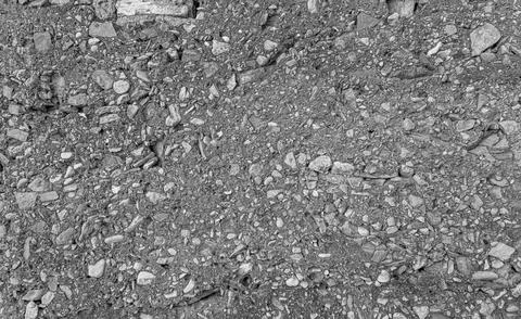 A close-up view of a rough and uneven gravel surface filled with small stones Stock Photos