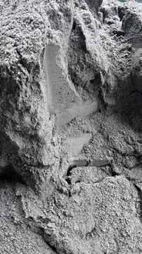 Close up view of rough gray sand with granular texture and a small cavity in Foto stock