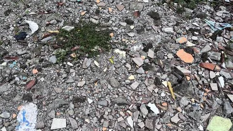Close view of a rough ground surface covered with small rocks, broken bricks, Stock Photos