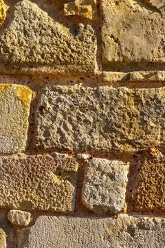 Close-up view of rough textured stone wall blocks in warm sunlight, showing.. Stock Photos