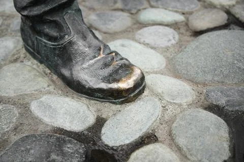 Close up view of rubbed bronze boot of statue . Part of statue  Polished by.. Stock Photos