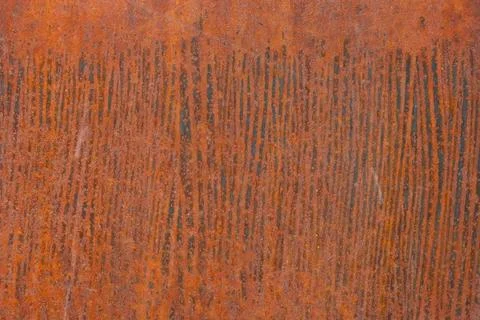 Close-up view of a rusted metal surface showcasing vertical linear patterns.  Stock Photos