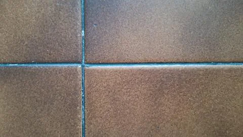 Close up view of rustic brown square ceramic floor tiles Stock Photos